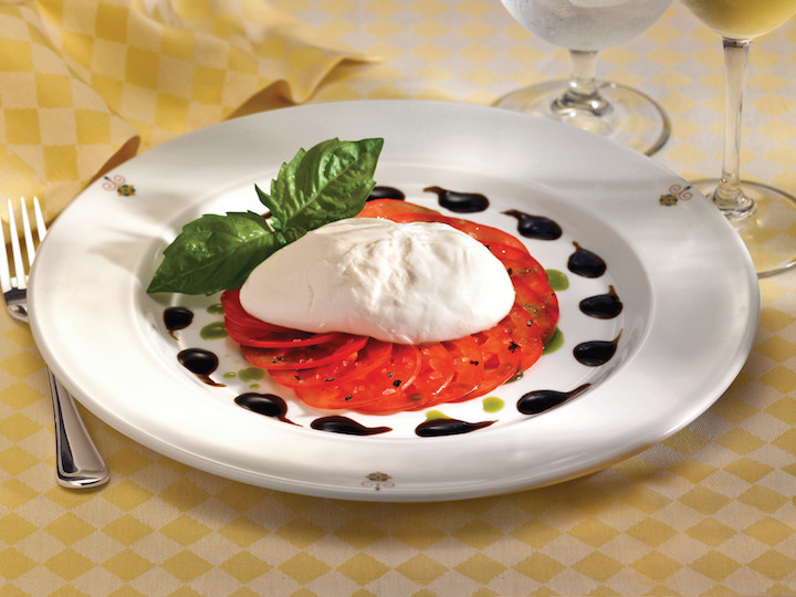 A light salad of fresh mozzarella and tomatoes dressed in tangy balsamic vinegar is a refreshing choice for a warm day.